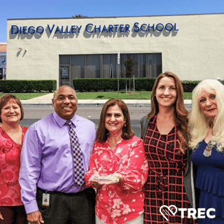 School leadership standing in front of the school building