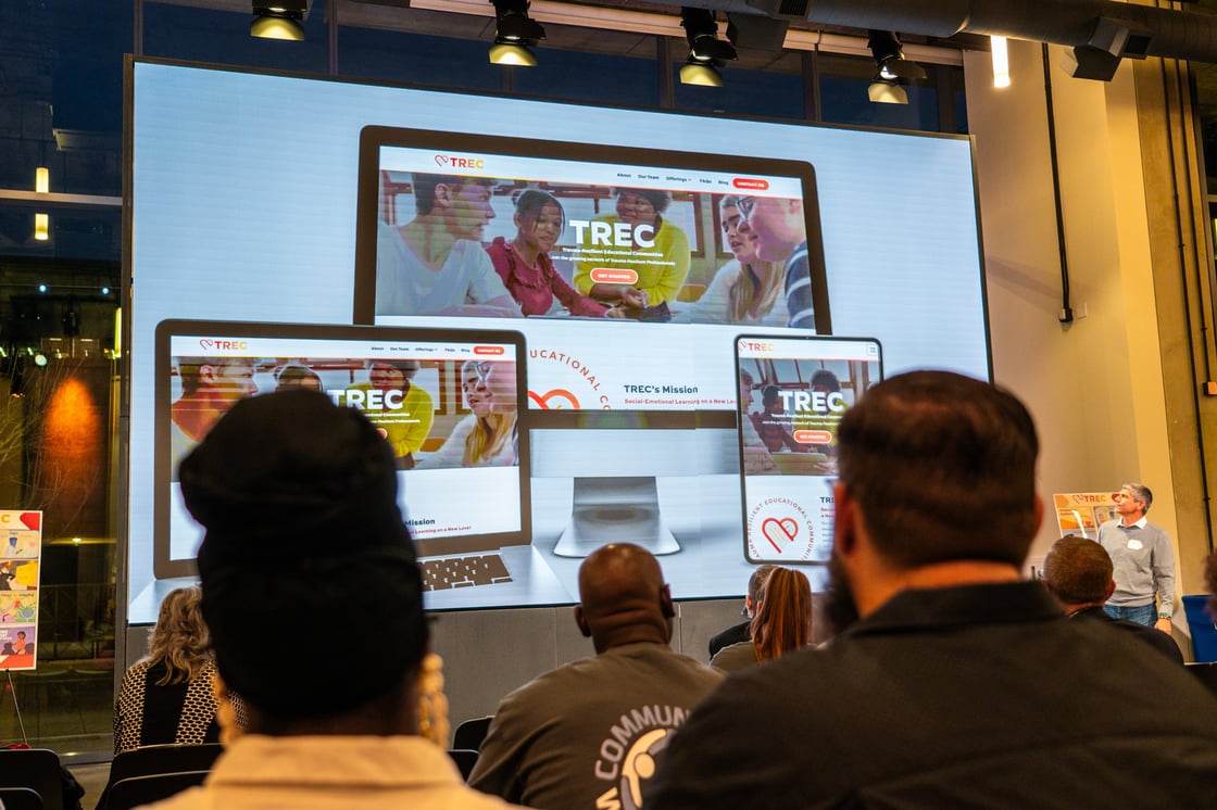 Audience watching a video about TREC on a big screen.